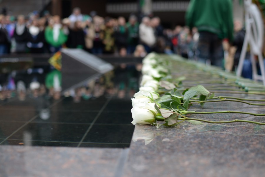 Members of the community and Marshall football players lay roses during the 44th annual Memorial Fountain Ceremony in commemoration of the 75 lives lost on the 1970. 