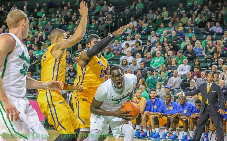 Senior forward Cheikh Sane protects the ball from MSU players as Marshall men's basketball falls to Morehead State University Wednesday at the Cam Henderson Center. 