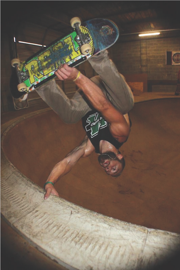Ryan George skates a bowl at an indoor skate park.