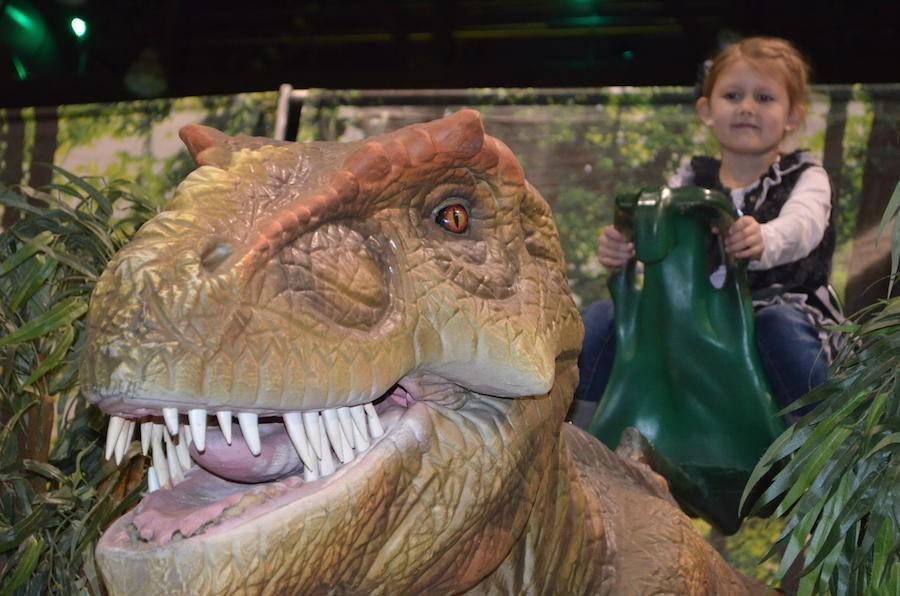 Sophie Chaney takes a ride on the animatronic T. Rex at ‘Discover the Dinosaurs’ at the Big Sandy Superstore Arena in Huntington Sunday.