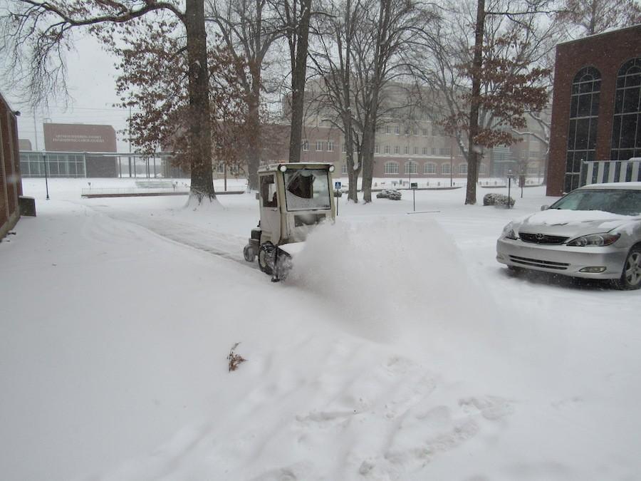 A snow plow clears a path beside the Communications Building. Record low temperatures and heavy snowfall forced Marshall University to close down four out of five days this week, but local businesses maintained steady customers. 