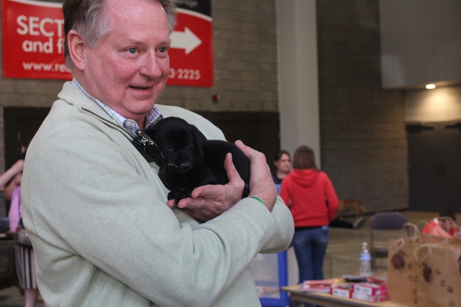 Huntington Mayor Steve Williams cuddles with a puppy at the Love is a Four Legged Word adoption celebration Saturday at the Big Sandy Superstore Arena.