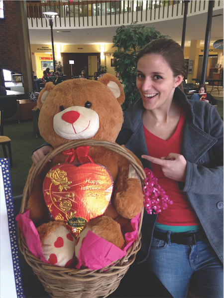 Mackenzie Lloyd, president of Alpha Kappa Psi at Marshall University, poses with the $90 raffle basket at the Memorial Student Center.