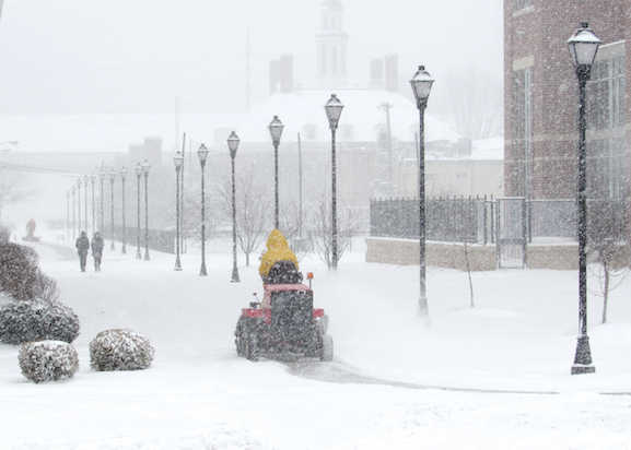 A snow plow fights against constant accumulation on campus Monday. 