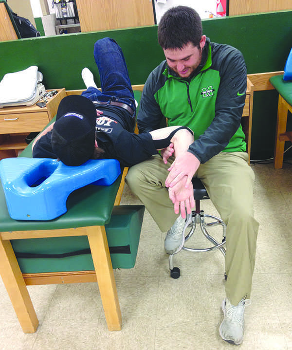 An athletic trainer helps an injured athlete at the Cam Henderson Center.