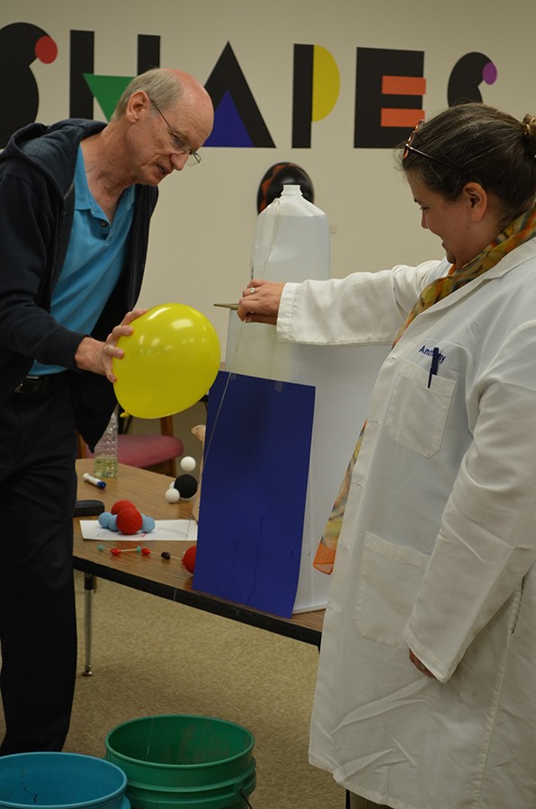 Mike Beck and Cindy Dearborn demonstrate how a stream of water can be bent using static electricity.