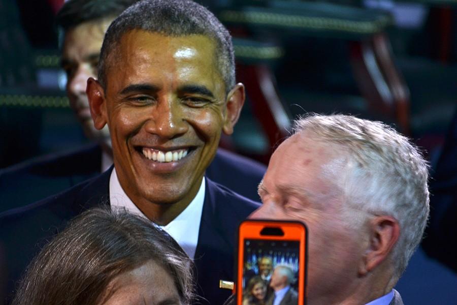 President Obama takes a selfie with members of the crowd.