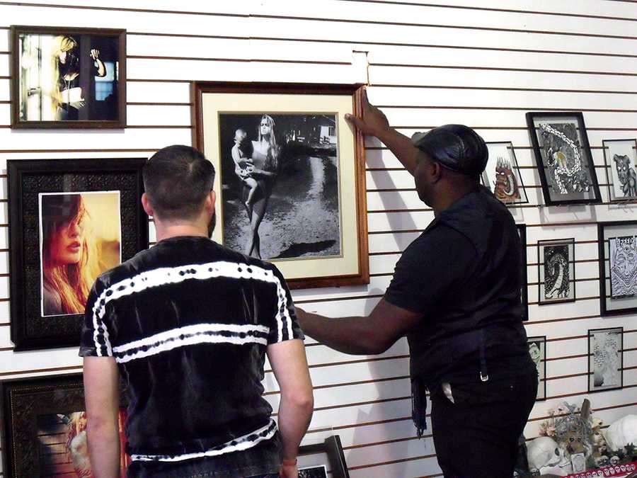 Keyamo Onage (right) , a photographer in the exhibit, hangs up his work with Joe Troubetaris (left) assisting. The art exhibit was curated by Two-Headed Dog Collective, a non-profit organization that creates temporary public safe spaces for the arts in Huntington.