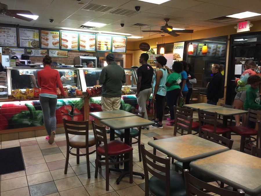 People+stand+in+line+that+wraps+around+the+building+inside+Subway+in+order+to+get+their+buy+one+get+one+sandwich.
