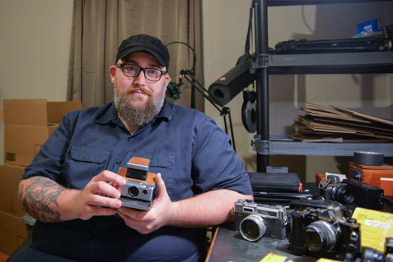 Photography enthusiast Michael Adkins showcases his camera collection inside his apartment on Thursday.