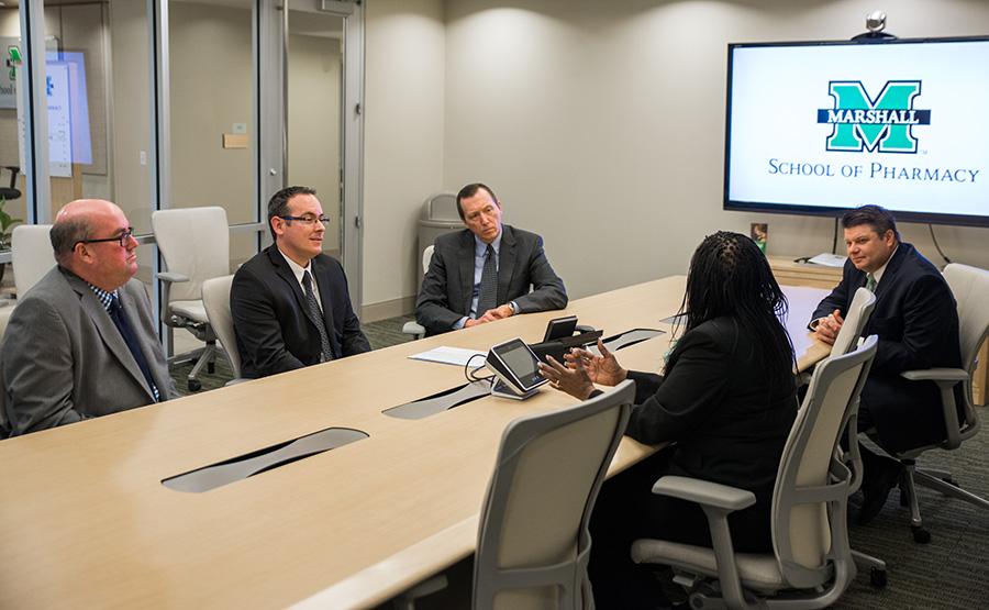Shelvy Campbell-Monroe, Ph.D., assistant dean for diversity describes diversity programs at the Marshall University School of Pharmacy to Walgreens representatives Christopher Keyfon (left) and D. Rich Miller, Ph.D. (second to left). Also in photo are Kevin W. Yingling, R.Ph., M.D. dean of the school of pharmacy (top left) and H. Glenn Anderson, Pharm. D., associate dean of academic and curricular affairs (top right).