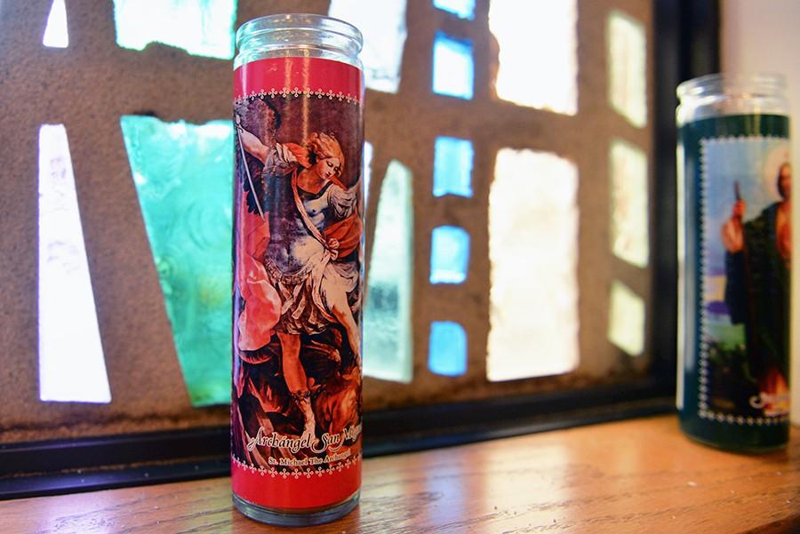 A votive candle honoring Saint Michael the Archangel sits along the windowsill at the Newman Center.