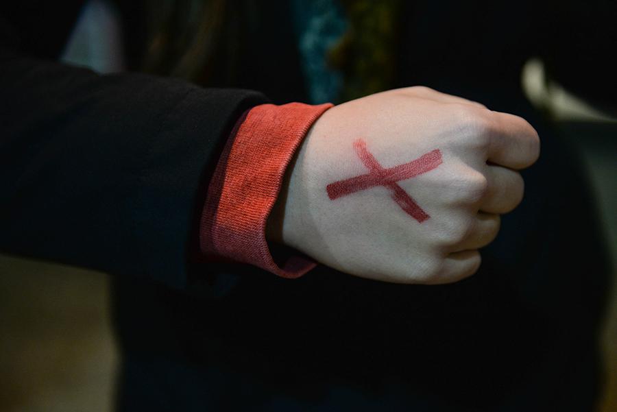 Marshall University students take turns standing outside the Memorial Student Center and sport red “Xs” on their hands in an effort to bring awareness to slavery and human trafficking on Thursday. The representatives spent a total of 27 hours to represent the 27 million currently enslaved.