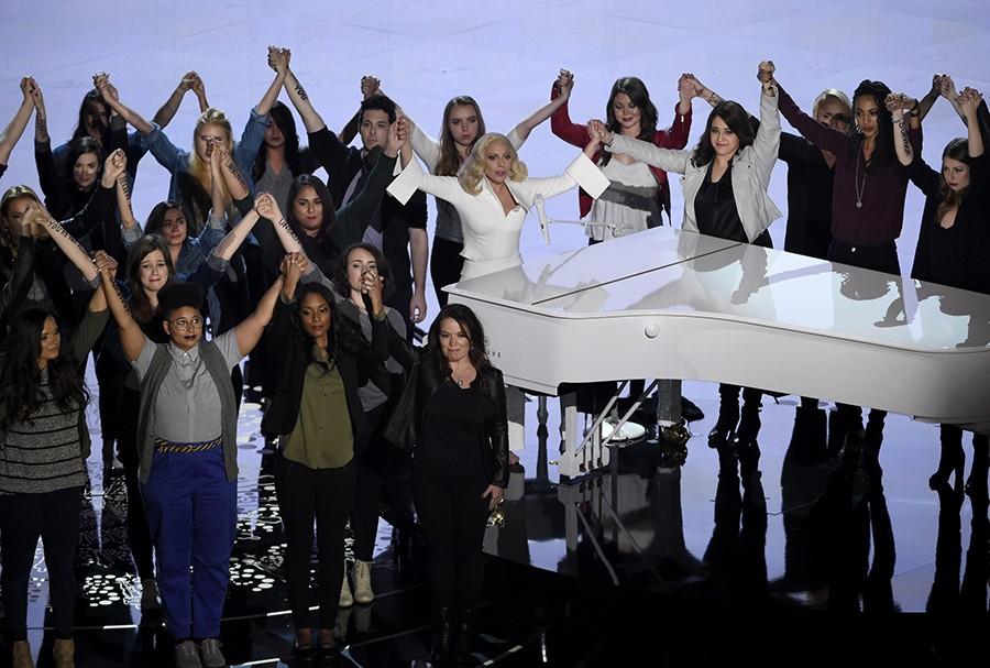 Lady Gaga, center, performs Til It Happens To You that is nominated for best original song from The Hunting Ground on stage with survivors of abuse at the Oscars on Sunday, Feb. 28, 2016, at the Dolby Theatre in Los Angeles.