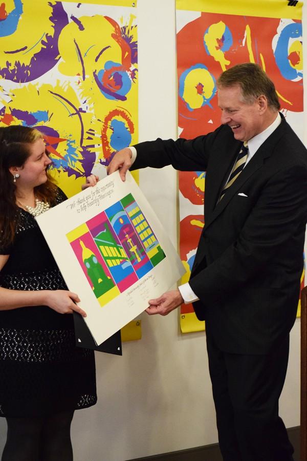 Junior graphic design student Brianna Jarvis presents her winning banners for the Winter 2016 category of the Huntington in Bloom banner contest to Mayor Steve Williams Tuesday at the Visual Arts Center.
