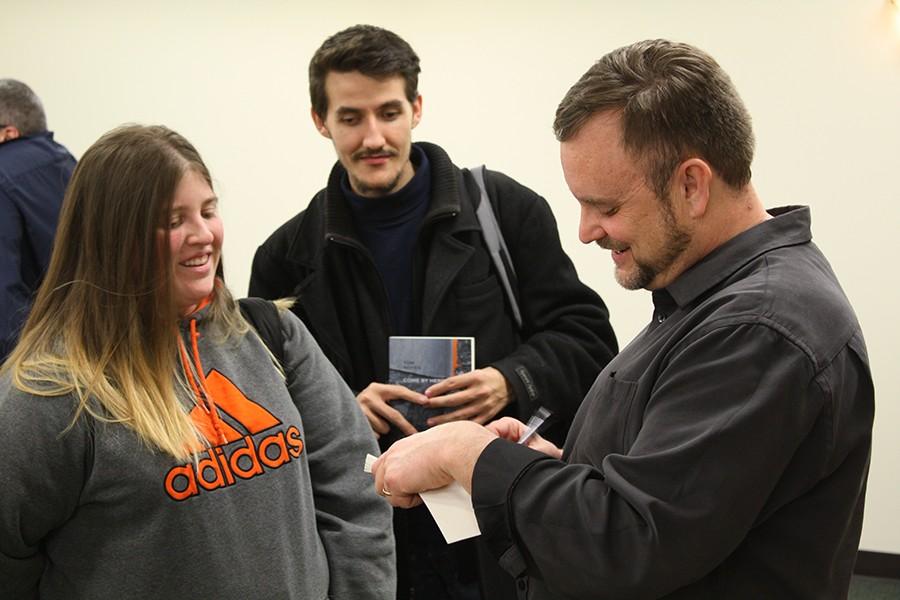 Writer Tom Noyes autographs copies of his latest fiction piece Come by Here: A Novella and Stories during the A.E. Stringer Visiting Writer Series on Tuesday in Room BE5 of the Memorial Student Center.