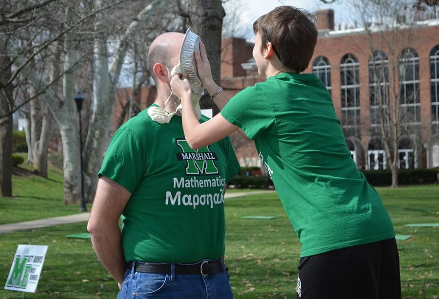 Kiersten Looney, treasurer of the Thundering Nerds, pies the face of Michael Schroeder, assistant professor of mathmatics, during Pi Day celebration Monday at Buskirk Field.