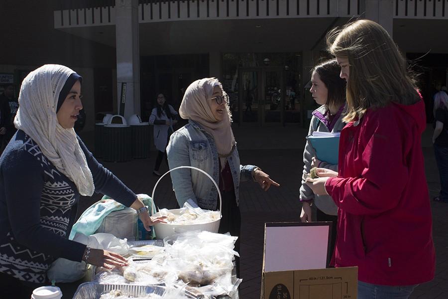 Grad student Makak Khader helps vend culturally themed goods to students at the Muslim Student Association bake sale outside the Memorial Student Center, April 5, 2016.