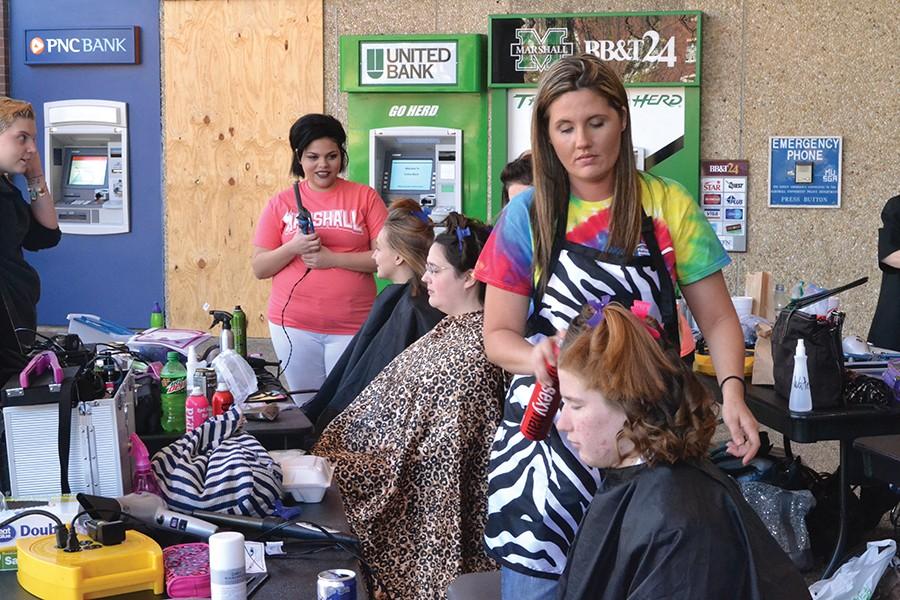Elementary education major Kayla Main donates hair with the help of Michal Bowling from Paramount Beauty during Hair for the Herd outside the Memorial Student Center, April 14, 2016.