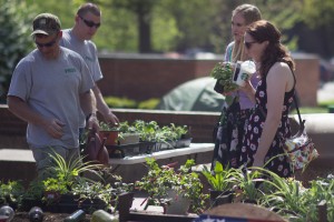 (From Right) Emily Bacchus and Hannah Blatt purchase plants from Alex Porter and Kole Labor during Earth Day at the Memorial Student Center, April 20, 2016.