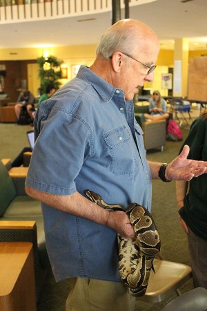 Larry Cartmill presents alongside his snake inside the Memorial Student Center during Earth Day, April 20, 2016.