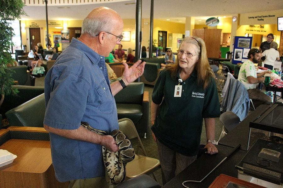 (From Left) Larry Cartmill speaks with desk coordinator Mary Tobey alongside his snake inside the Memorial Student Center during Earth Day, April 20, 2016.