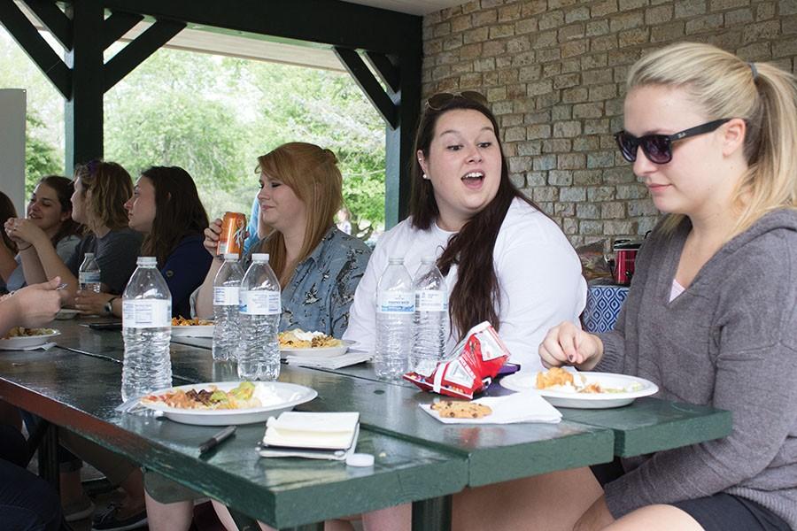 (From Right) Honors students Natalie Irwin, Ashley DeMoss, and Sarah McComas eat at the taco salad bar provided at the Honors College picnic in Ritter Park, April 21, 2016.