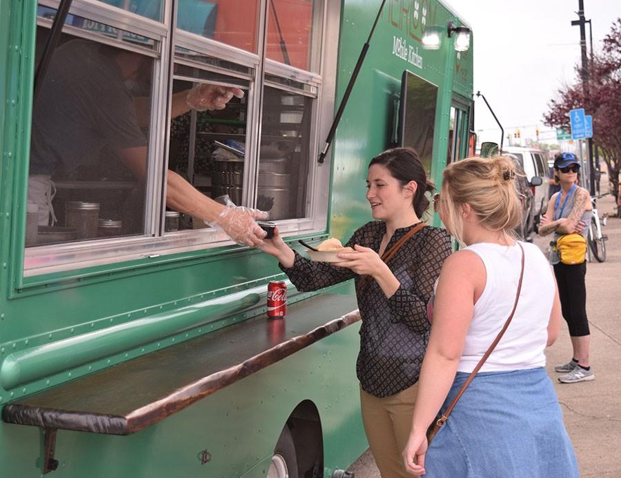 (From Left) Two Bernie supporters purchase a meal from Heirloom mobile kitchen outside the Bernie Sanders rally at the Big Sandy Superstore Arena, April 26, 2016.