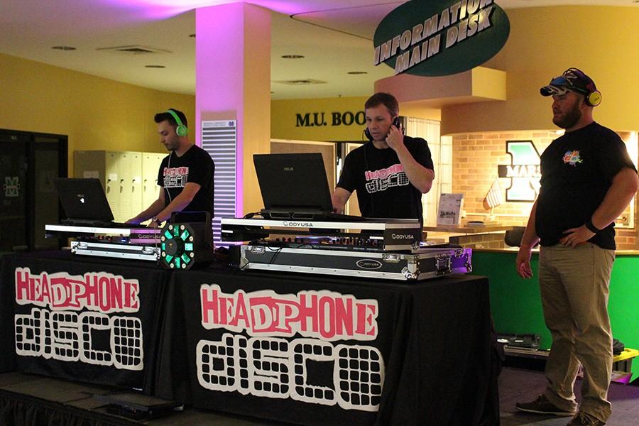 Headphone Disco’s DJs Kory Scott (left) and Steven Crandall (middle) perform as Jacke Saunders of CAB (right) takes in the scene Wednesday in the Memorial Student Center lobby.