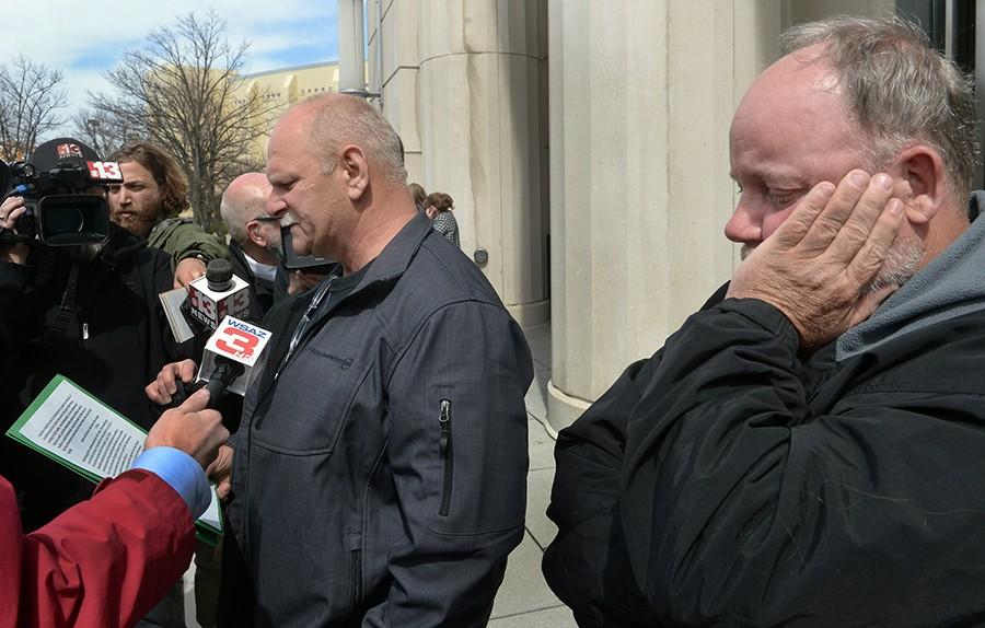 Clay Mullins, left, who lost his brother Rex Mullins in the Upper Big Branch explosion, reads the statement that he was not allowed to read during the sentencing of former Massey CEO Don Blankenship as Gary Quarles, right, who lost his son, takes in the emotion of the day Wednesday, April 6, 2016 in Charleston, W.Va. Blankenship was sentenced to a year in jail and a $250,000 fine for his role in the fatal 2010 blast.
