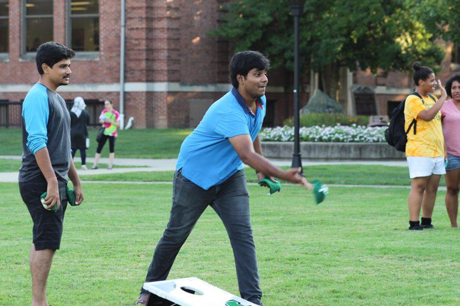 (From left) Computer sciences junior Ramu Avvaru plays cornhole with graduate Akhil Parupalli at the INTO Open House, August 29, 2016.