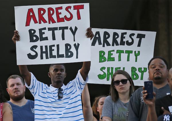 People hold signs at a "protest for justice" over Friday's shooting death of Terence Crutcher, sponsored by We the People Oklahoma, in Tulsa, Okla., Tuesday, Sept. 20, 2016. (AP Photo/Sue Ogrocki)