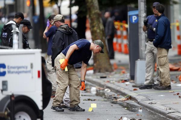 Evidence teams investigate at the scene of Saturday's explosion on West 23 Street in Manhattan's Chelsea neighborhood, Monday, Sept. 19, 2016, in New York. An Afghan immigrant wanted for questioning in the bombings that rocked a New York City neighborhood and a New Jersey shore town was captured Monday after being wounded in a gun battle with police. (AP Photo/Jason DeCrow)