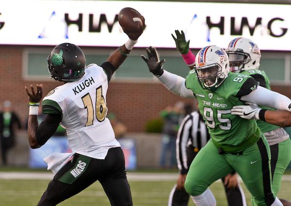 Charlotte 49ers QB Hasaan Klugh just manages to get off his pass as Marshall University Defensive Tackle Tomell One put on the pressure during Thundering Herd football action Saturday afternoon at Joan C. Edwards Stadium in Huntington. Bob Wojcieszak/Parthenon