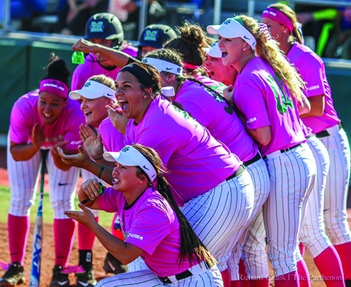 The Marshall University Softball team gathers around home plate celebrating a home run hit by sophomore Abigail Estrada Friday in the bottom of the second inning leading to a 4-2 win over FAU.