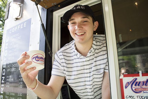 Grindstone employee Hunter Way poses with a cup of Austins Ice Cream.