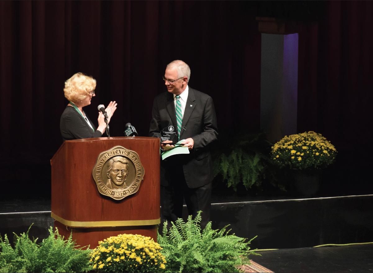 History professor and Drinko Fellow Montserrat Miller presents Marshall President Jerry Gilbert with an award from the
John Deaver Drinko Academy of Marshall University following Gilbert’s Thursday lecture on civic responsibility during the
seventh annual Robert C. Byrd Forum on Civic Responsibility.