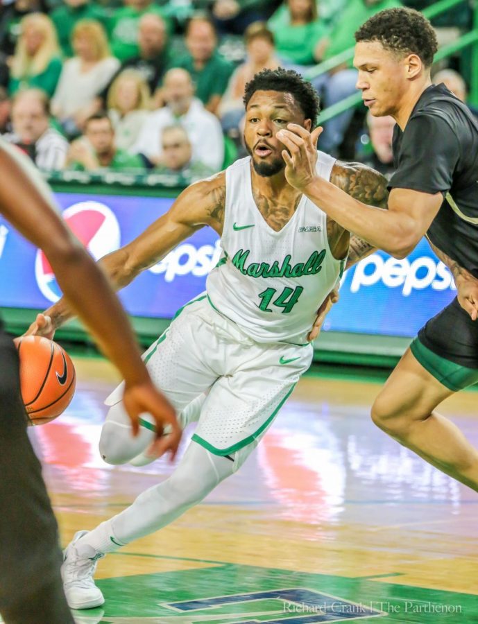 Junior guard C.J. Burks drives through Charlotte's defense as he attempts to score inside the paint. Burks hits six of his sixteen shots on the night.