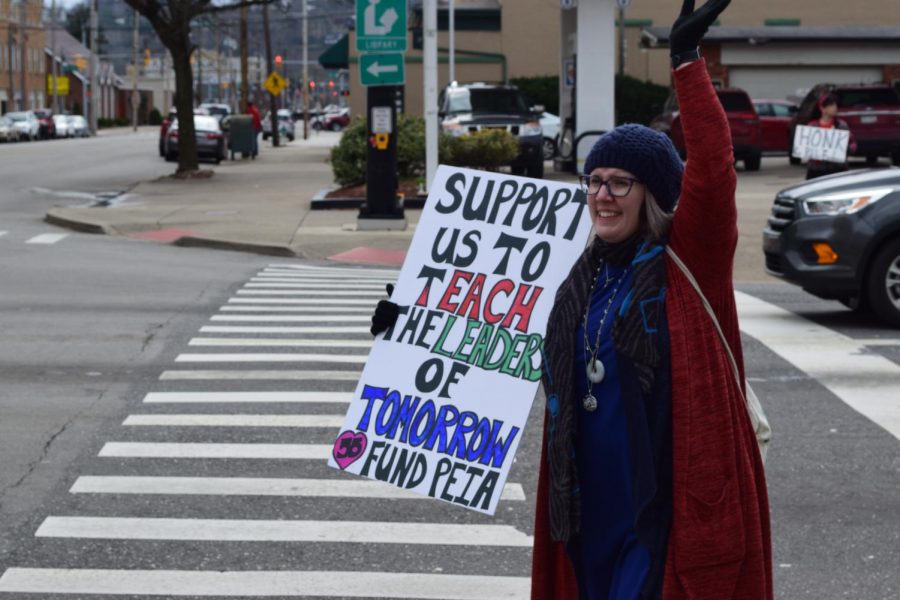 Teachers outside on 5th Avenue of Huntington, West Virginia holding signs calling for increased pay raises and lower deductibles and insurance rates. 