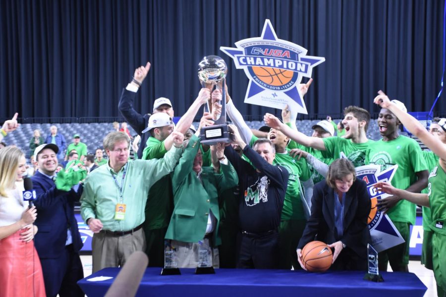 Marshall Universty athletic director Mike Hamrick, president Jerry Gilbert, head coach Dan D’Antoni and members of the team hold up the Conference USA championship trophy following the Herd’s win over Western Kentucky.