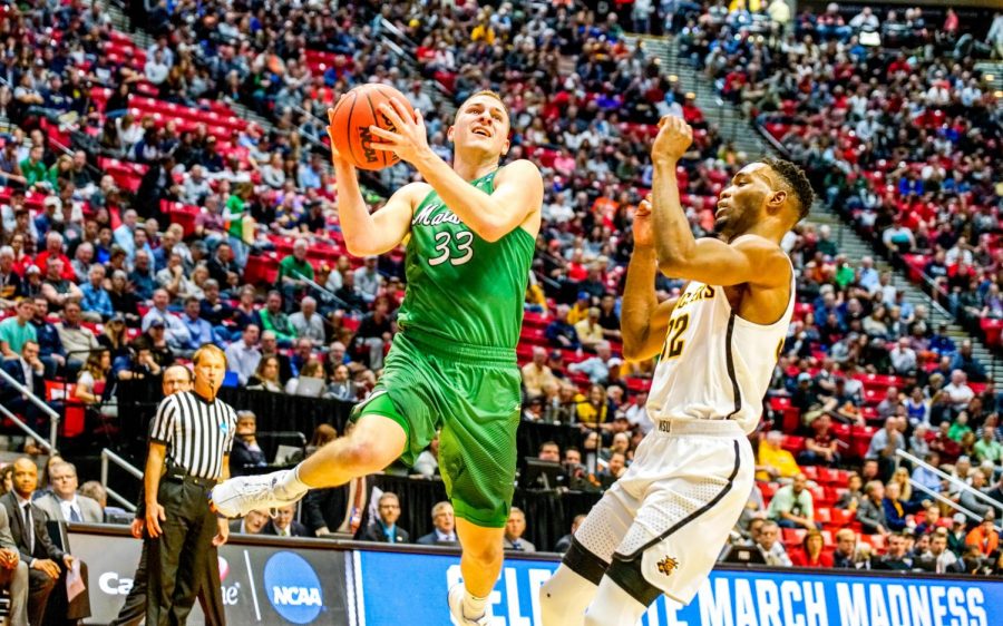 Junior guard Jon Elmore goes airborne for a layup around Wichita State sophomore forward Markis McDuffie. Elmore uses his versatility to score inside the paint, supplementing his three-point shooting.