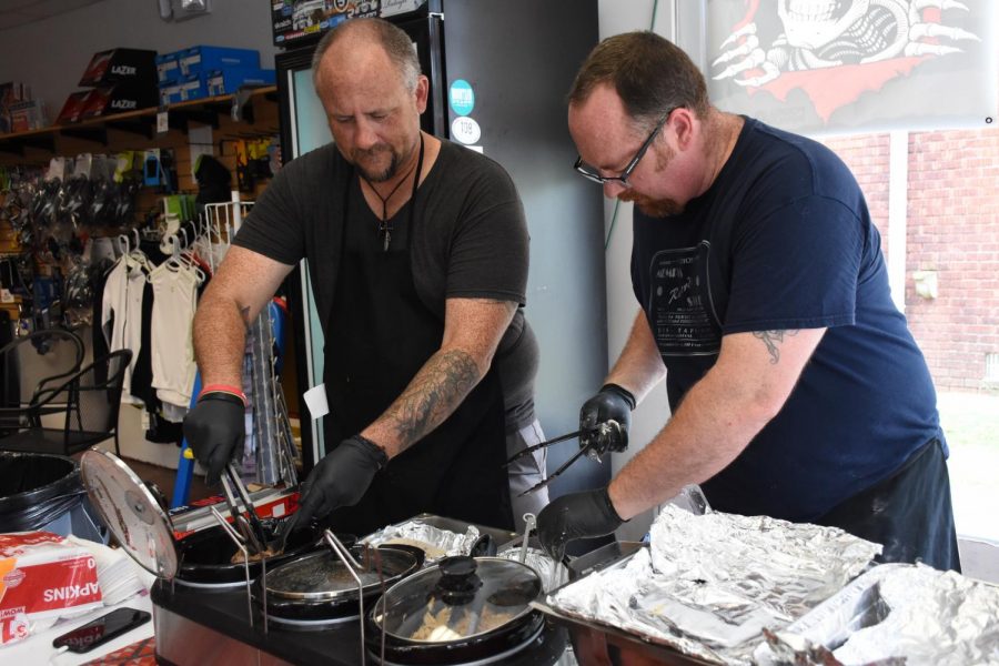 Tim Watson (left) and Chris Wood (right) preparing a buffalo taco at their pop-up shop at Huntington Cycle and Sport.