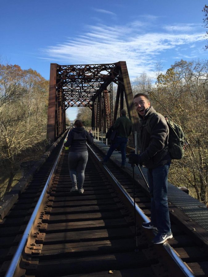 Kelsey Peters, Weston Wright and Josh Dehaven cross a bridge during Hiking Herd’s recent hike at Barboursville Park.