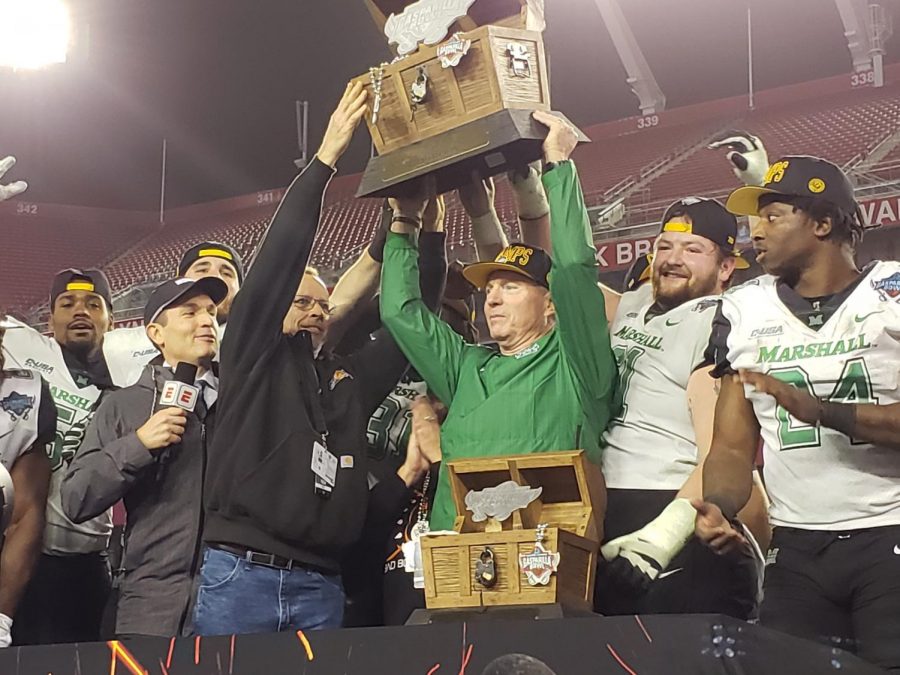 Head coach Doc Holliday (center) holds up the 2018 Bad Boy Mowers Gasparilla Bowl trophy following Marshalls 38-20 win over South Florida