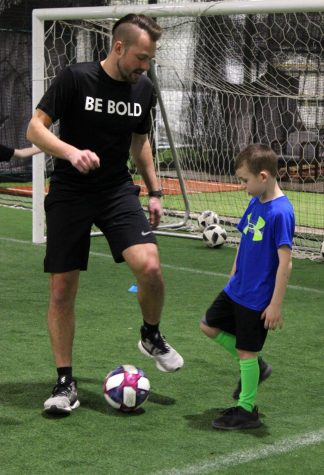 Kyle Sniatecki teaches clients how to do an exercise at a training March 11.