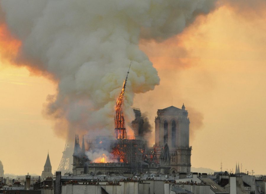 Flames and smoke rise from the blaze as the spire starts to topple on Notre Dame Cathedral in Paris, Monday, April 15.