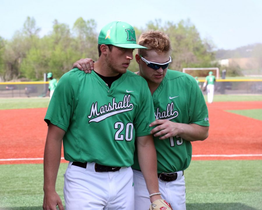 Zach Inskeep (right) offers advice to Evan Hurn (left) between innings. 