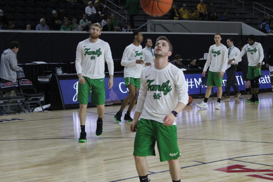 Marshall men’s basketball co-head manager Jacob Garnes (center) rebounds a shot during warmups as Thundering Herd players go through shooting drills prior to a Conference USA Tournament game against Southern Miss on March 14.