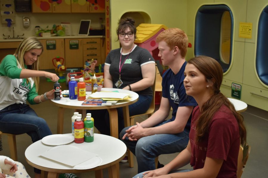 Marshall students Olivia Hart, Jodi Grimmett, Kaden Thomas and Caroline Foreman prep an activity with direction from one of the children. 