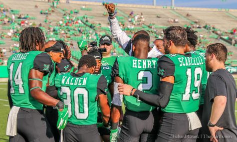 Members of the Marshall football team huddle together prior to the start of the game against VMI.
